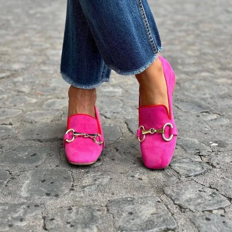 Green suede flat loafers with a round toe and silver metal fastener on the front.