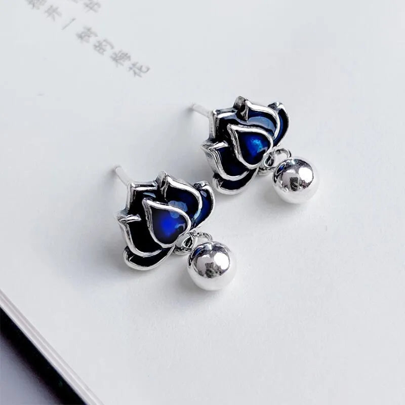 Blue alloy lotus seedpod earrings with tassel detail, shown as a pair of dangle drop studs.