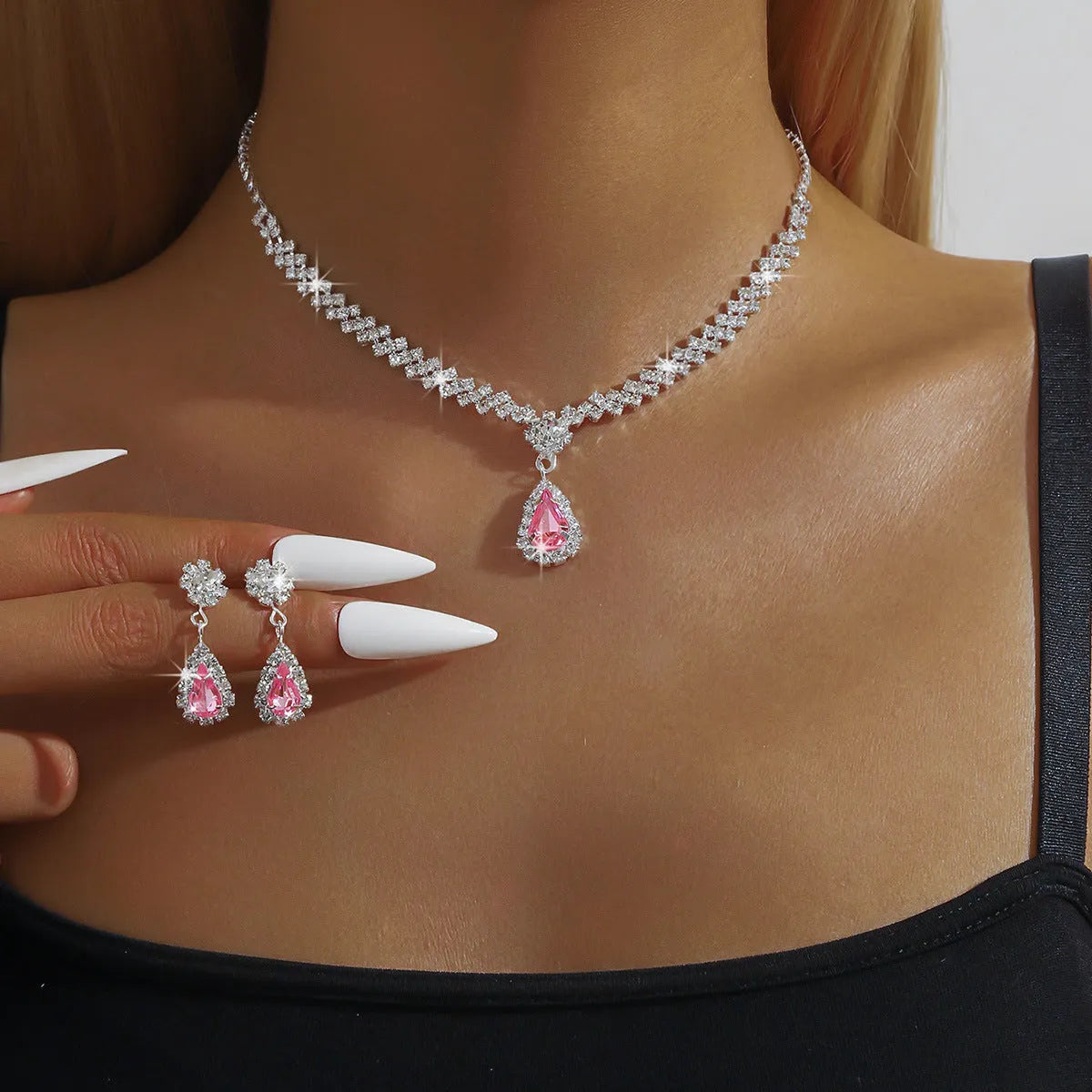 Women's rhinestone water drop necklace and earrings set on a claw chain in blue colour.