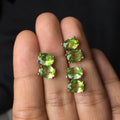 Natural grass green olivine faceted stud earrings in S925 silver settings on a white background.