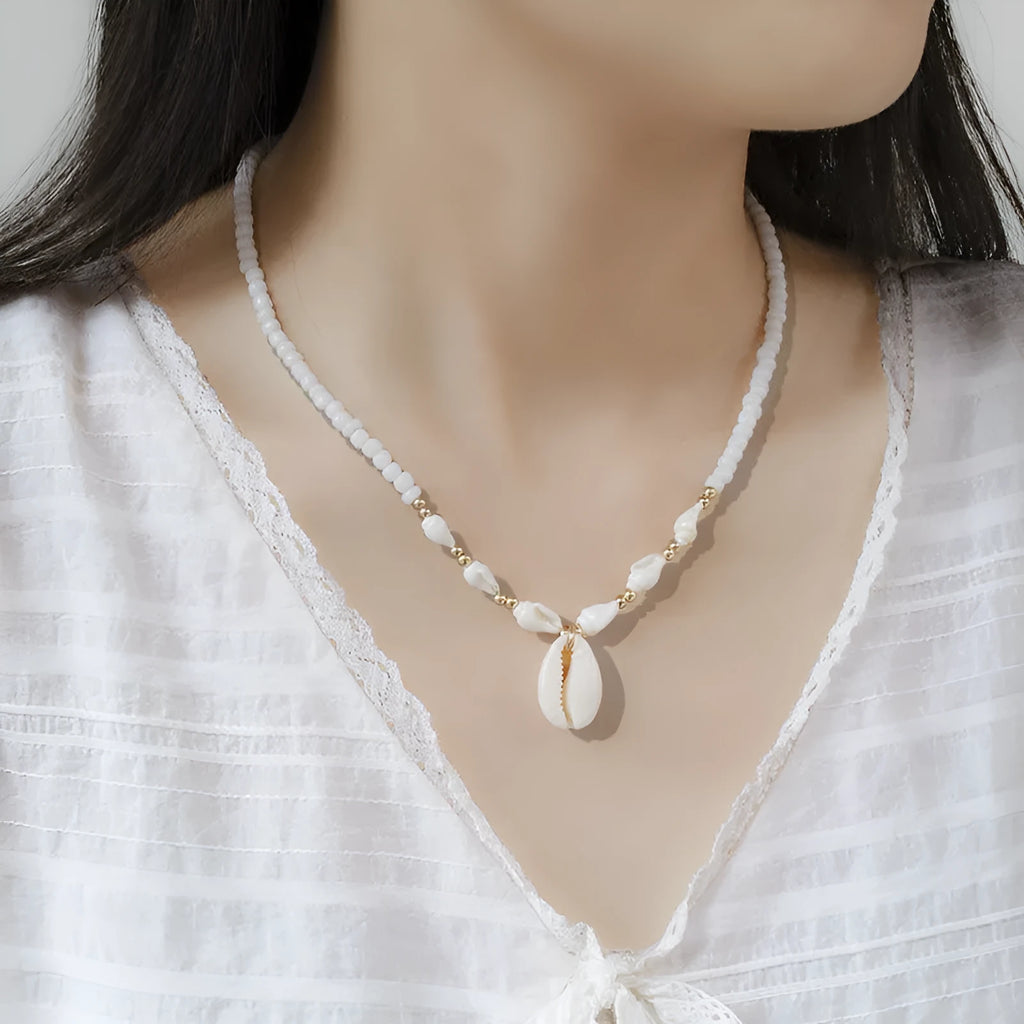 White conch shell necklace with mother of pearl pendant and beads on a chain.
