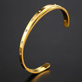 Open-ended stainless steel bracelet for women with inlaid zircon stones, shown in gold colour.