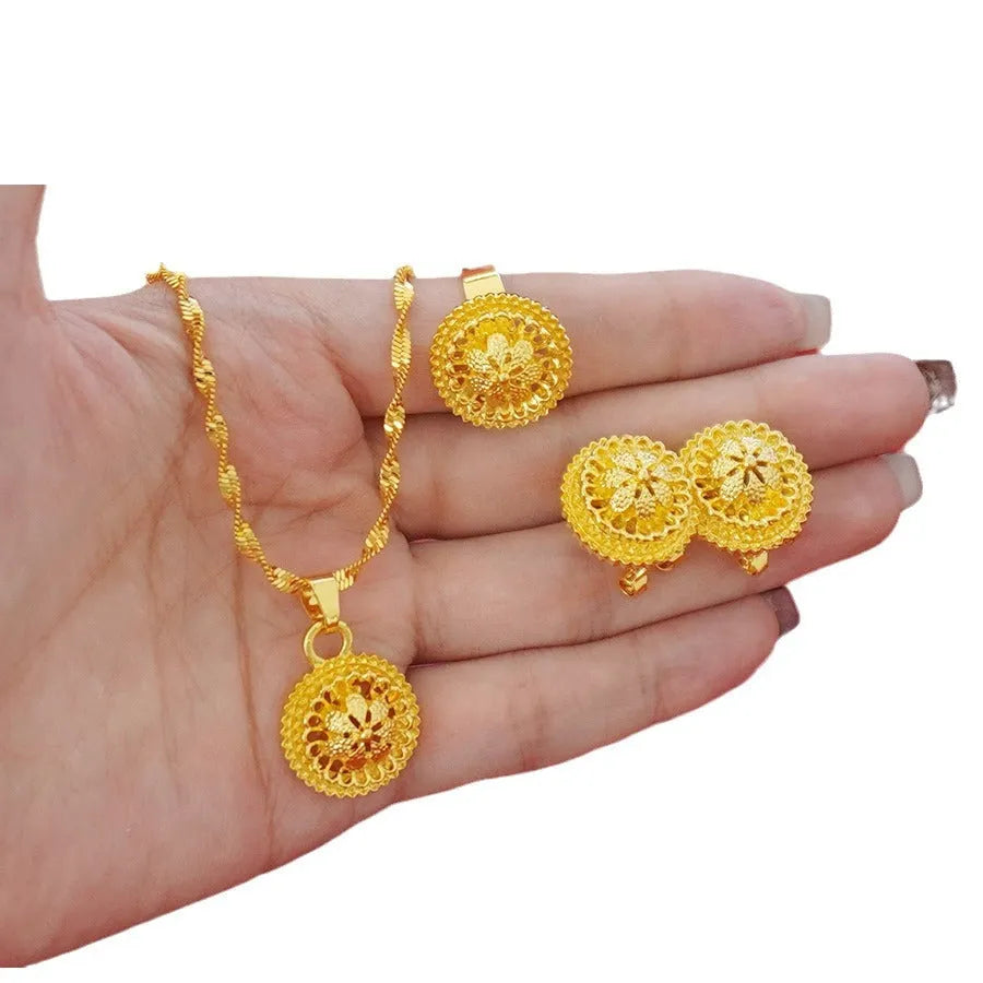 Gold-plated three-piece jewellery set with floral designs including necklace, earrings, and ring