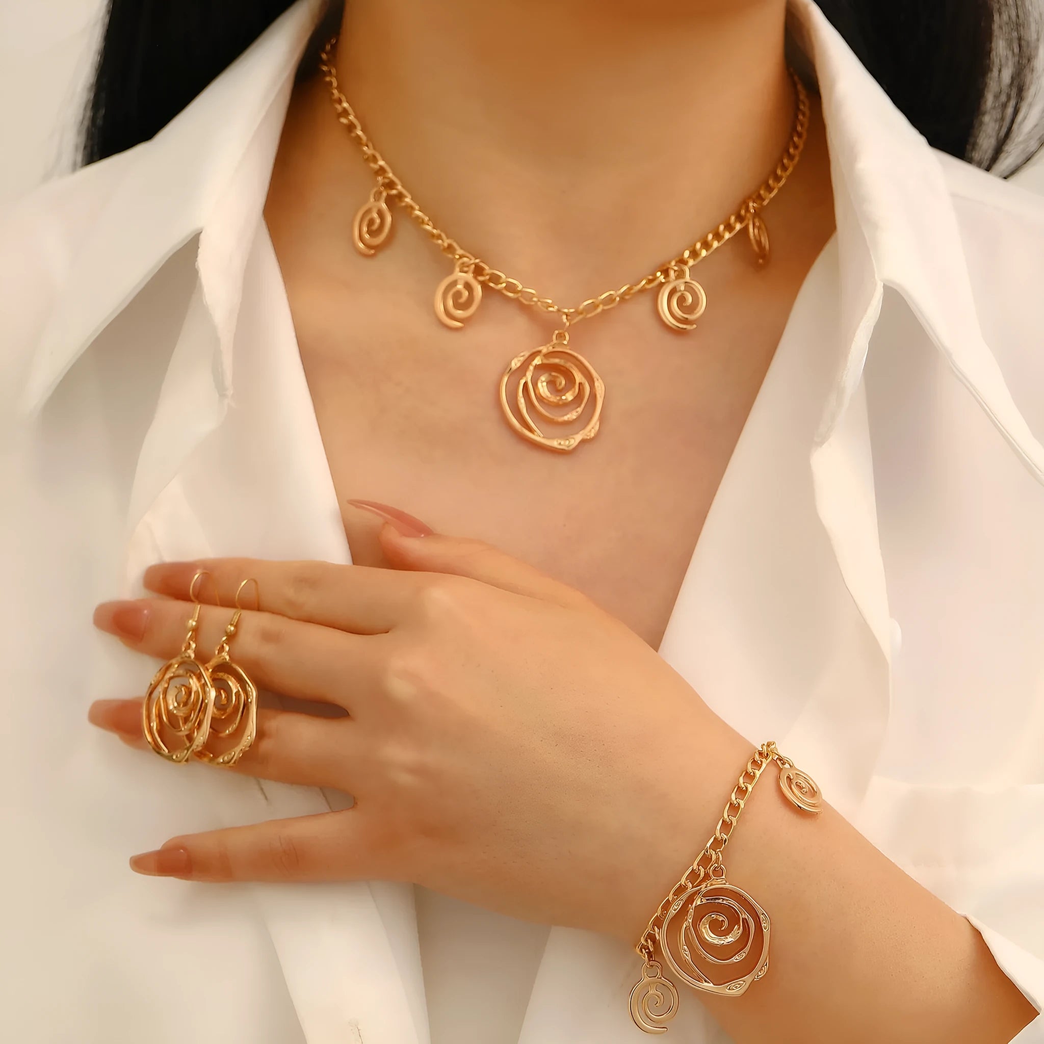 Spiral donut jewellery set showing necklace, bracelet and ear hooks in gold finish with geometric circle design
