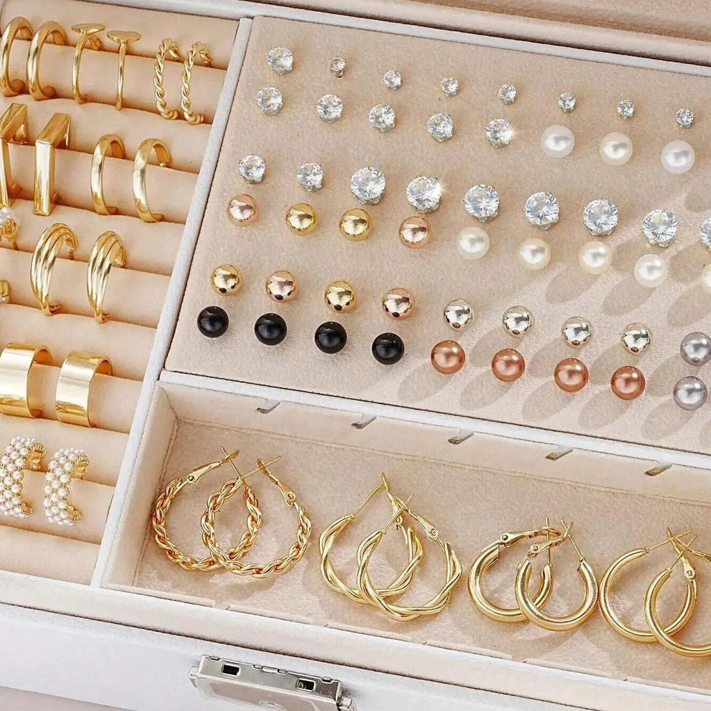 108 gold and yellow alloy stud earrings with geometric shapes and round pearl details on a plain surface.