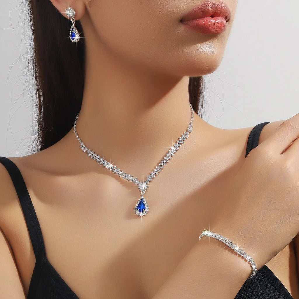 Women's rhinestone water drop necklace and earrings set on a claw chain in blue colour.