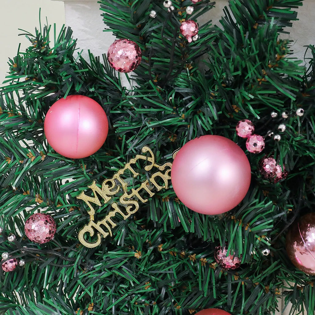 Pink artificial Christmas rattan garland with small berries and warm white LED lights draped on a mantelpiece.