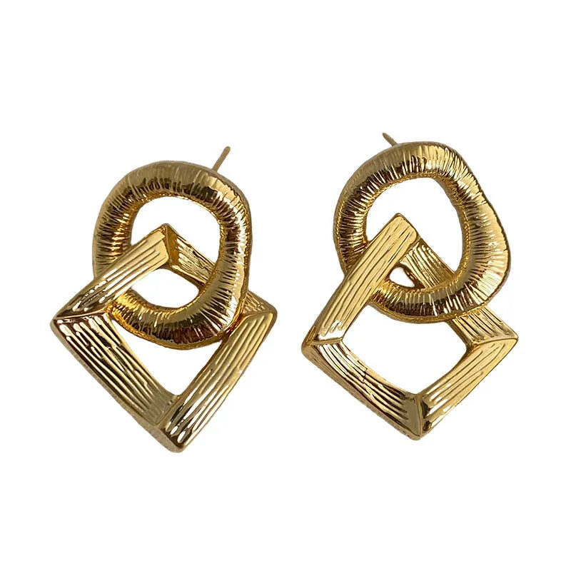 Geometric circle drop pendant earrings in gold or silver finish, showing 3.4cm length on a copper base.