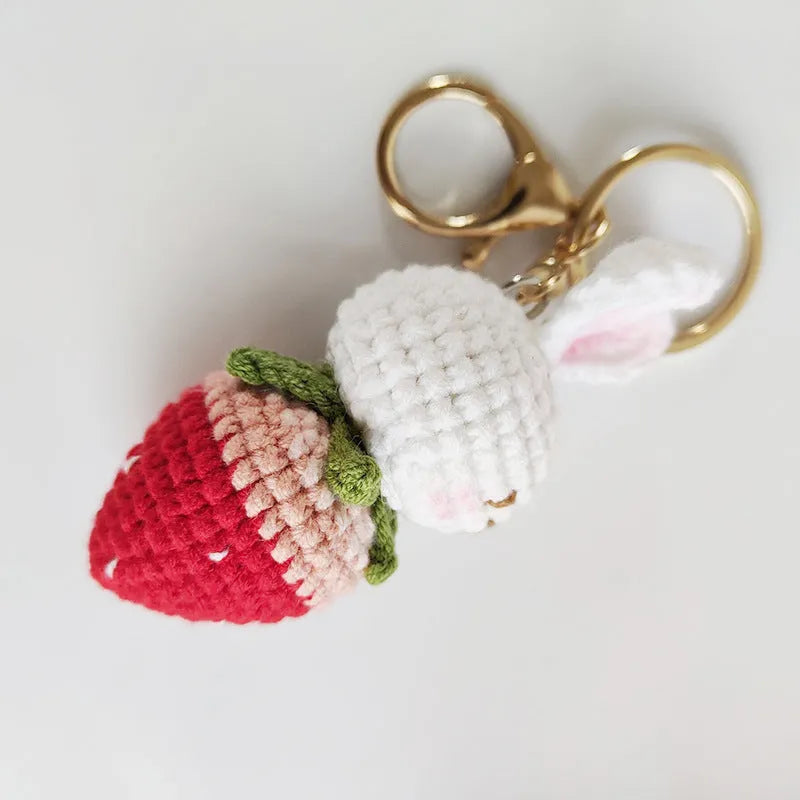 Hand-woven white rabbit and strawberry cartoon pendant on a key, made from braided doll wire.