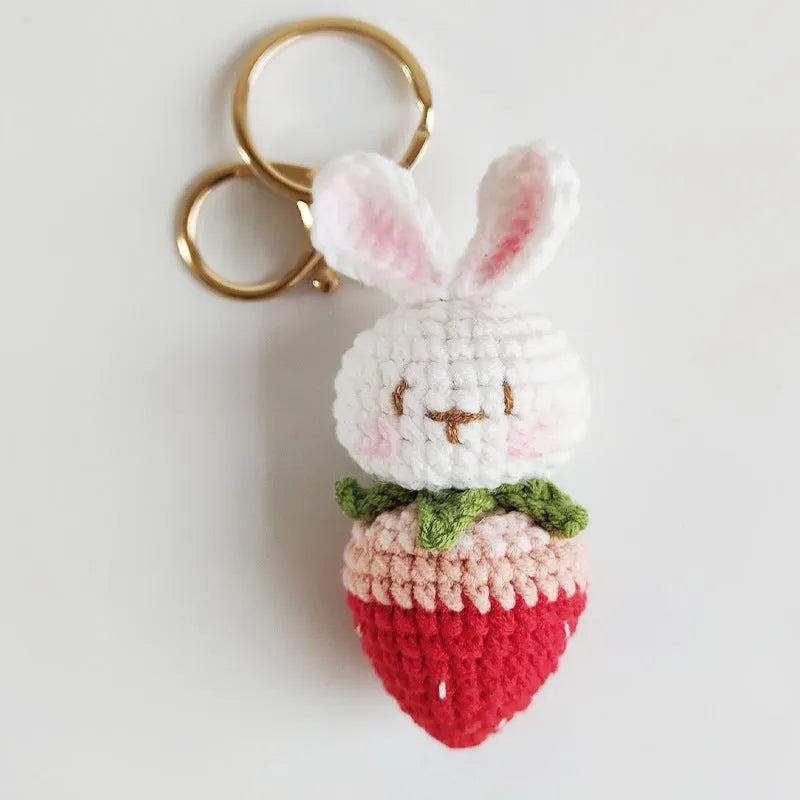 Hand-woven white rabbit and strawberry cartoon pendant on a key, made from braided doll wire.