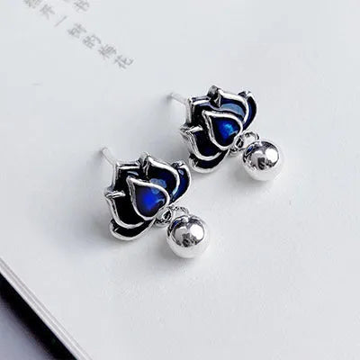 Blue alloy lotus seedpod earrings with tassel detail, shown as a pair of dangle drop studs.