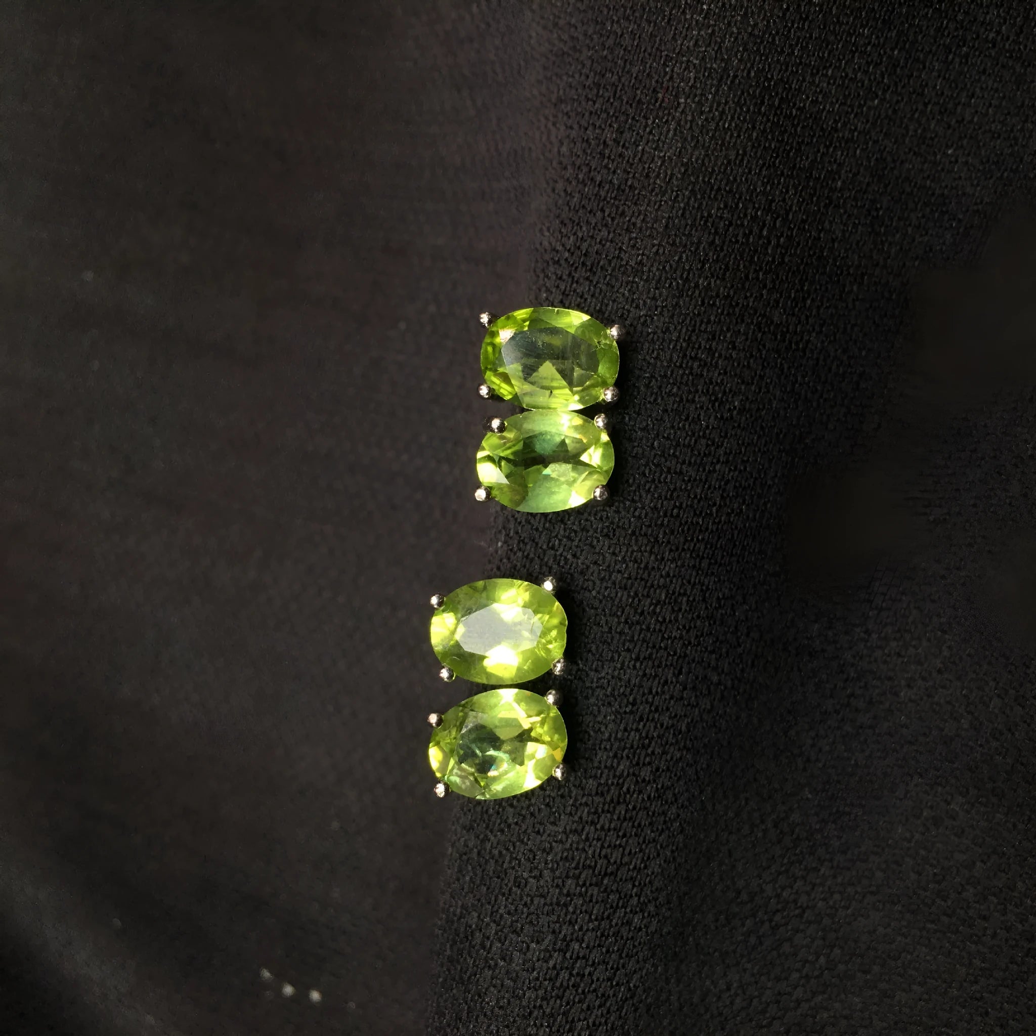 Natural grass green olivine faceted stud earrings in S925 silver settings on a white background.