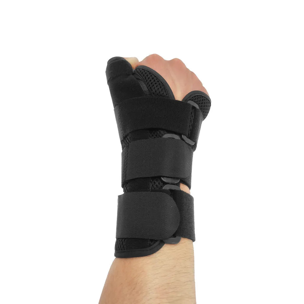 Black carbon fibre pattern wrist guard with grey edging and a white thumb strap, shown on a left hand.