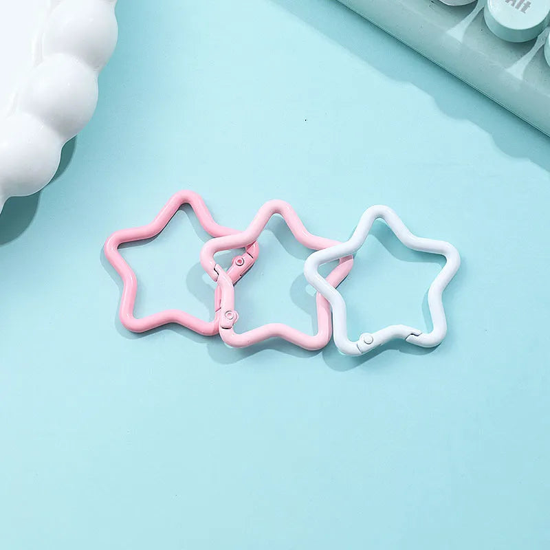 Zinc alloy five-pointed star keychain in assorted macaron colours including pink, blue, and purple