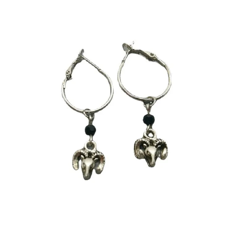 Silver Tibetan antelope round ring drop dangle earrings on a white background.