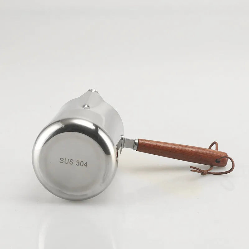 Stainless steel barista milk jug with measurement scale and wooden handle shown in 350ml, 600ml, and 1000ml sizes.