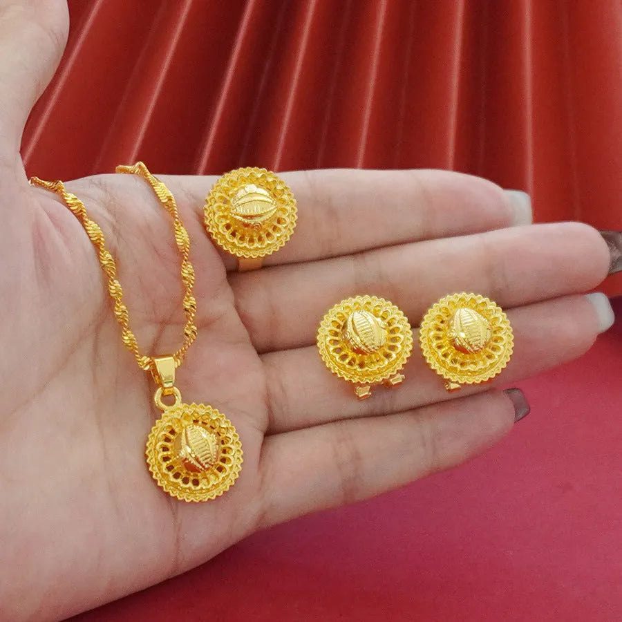 Gold-plated three-piece jewellery set with floral designs including necklace, earrings, and ring