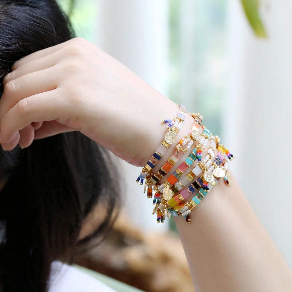 Handcrafted women's bracelet featuring imitation pearls and coloured glass beads on a wrist.
