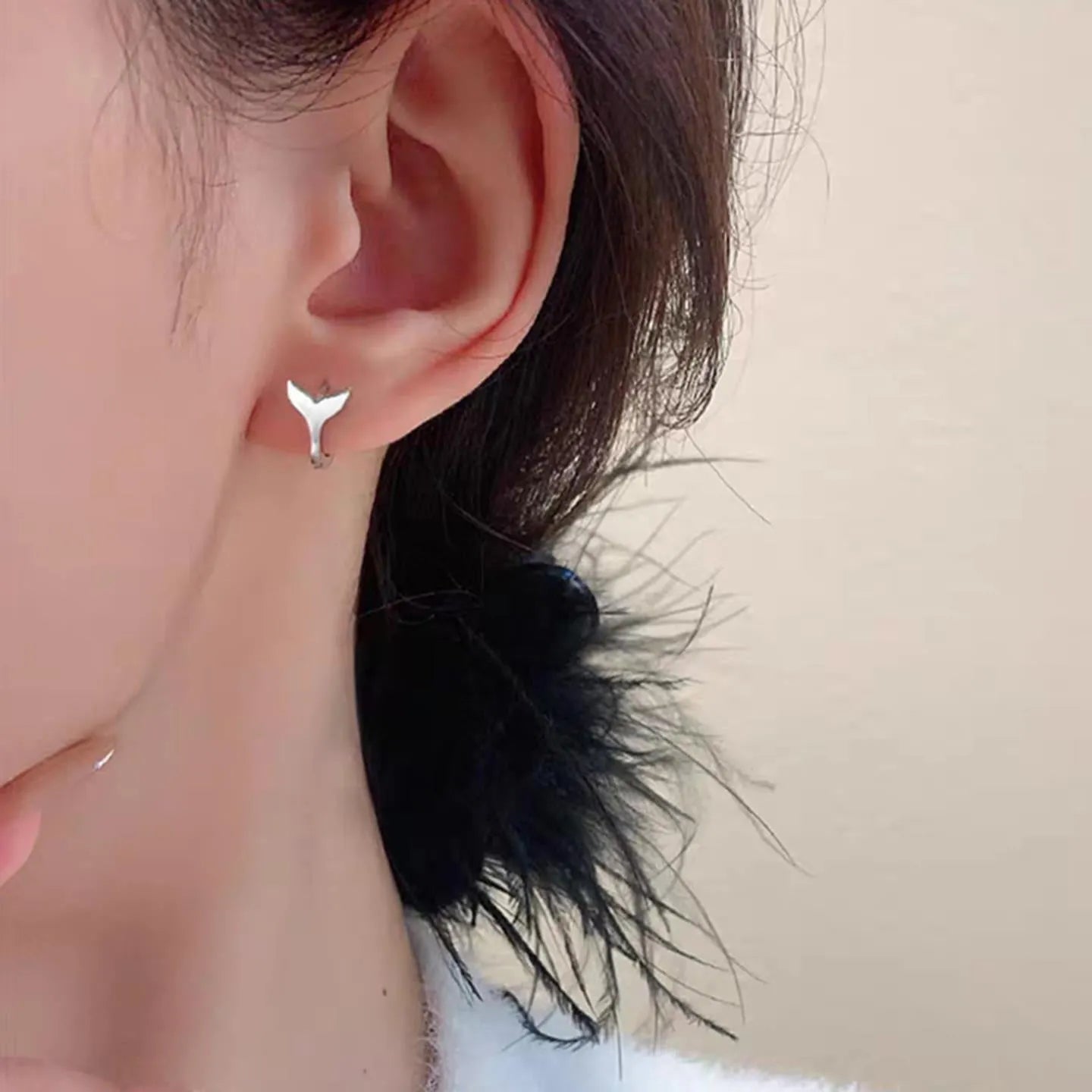 Women's fishtail design earrings in electroplated White Gold colour on a white background.