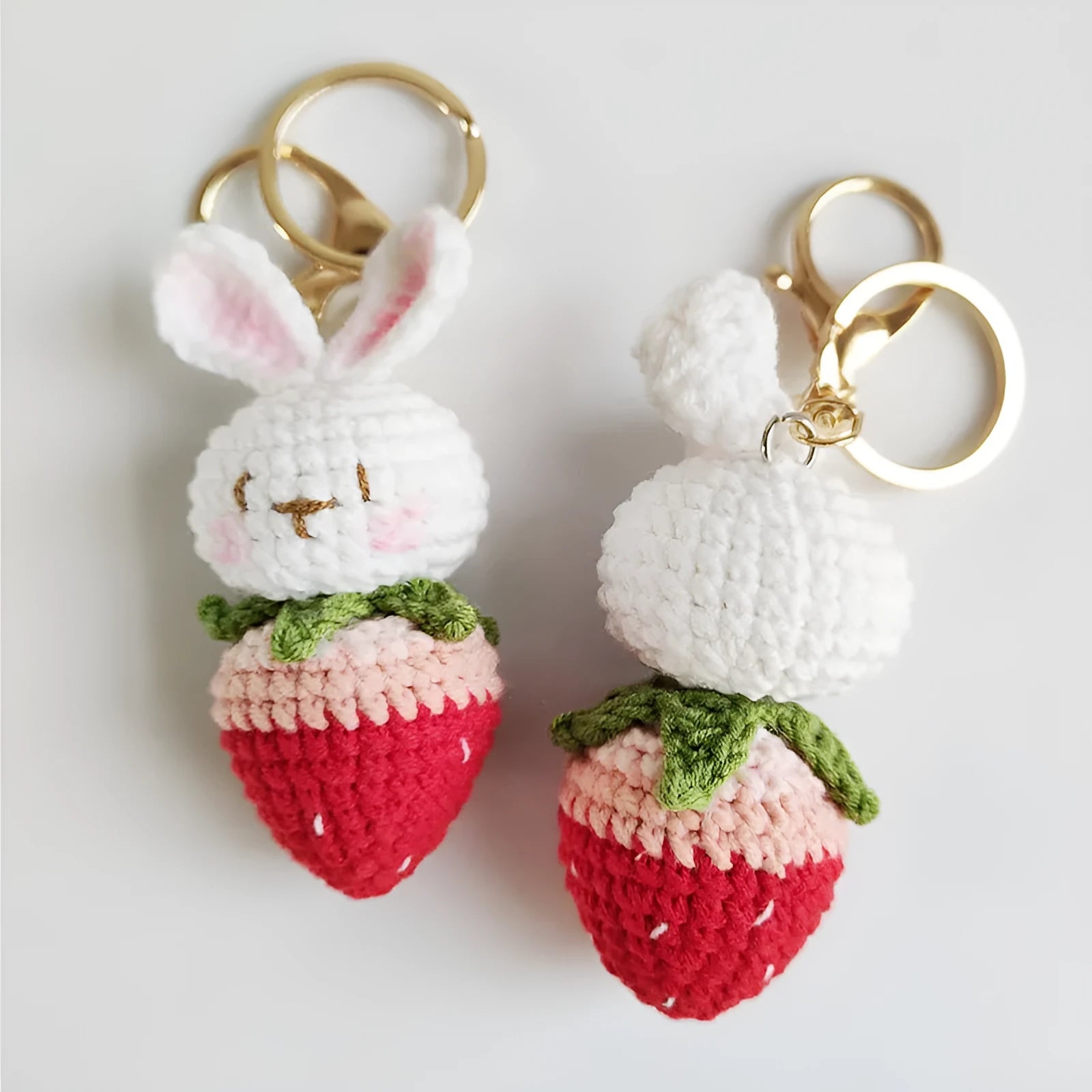 Hand-woven white rabbit and strawberry cartoon pendant on a key, made from braided doll wire.