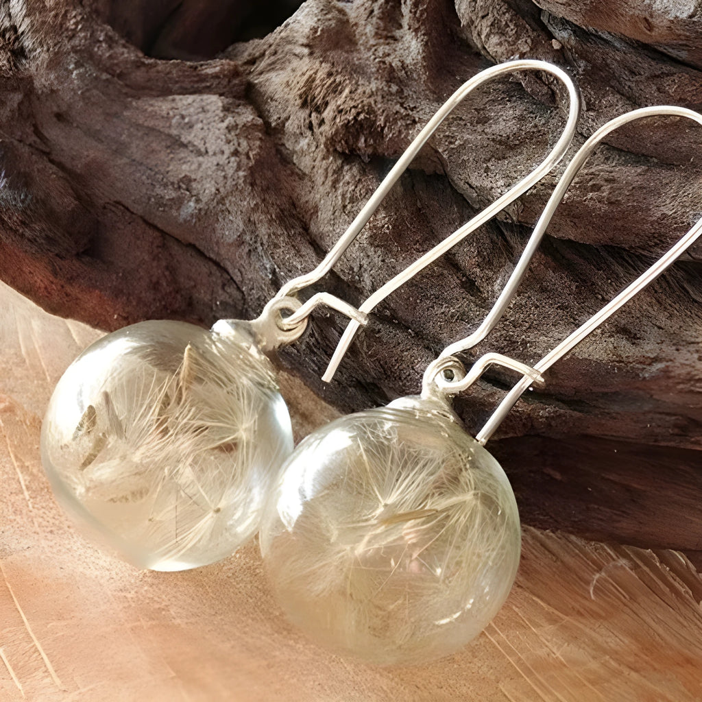 Transparent glass ball earrings with dandelion seed design on a French hook in silver finish.