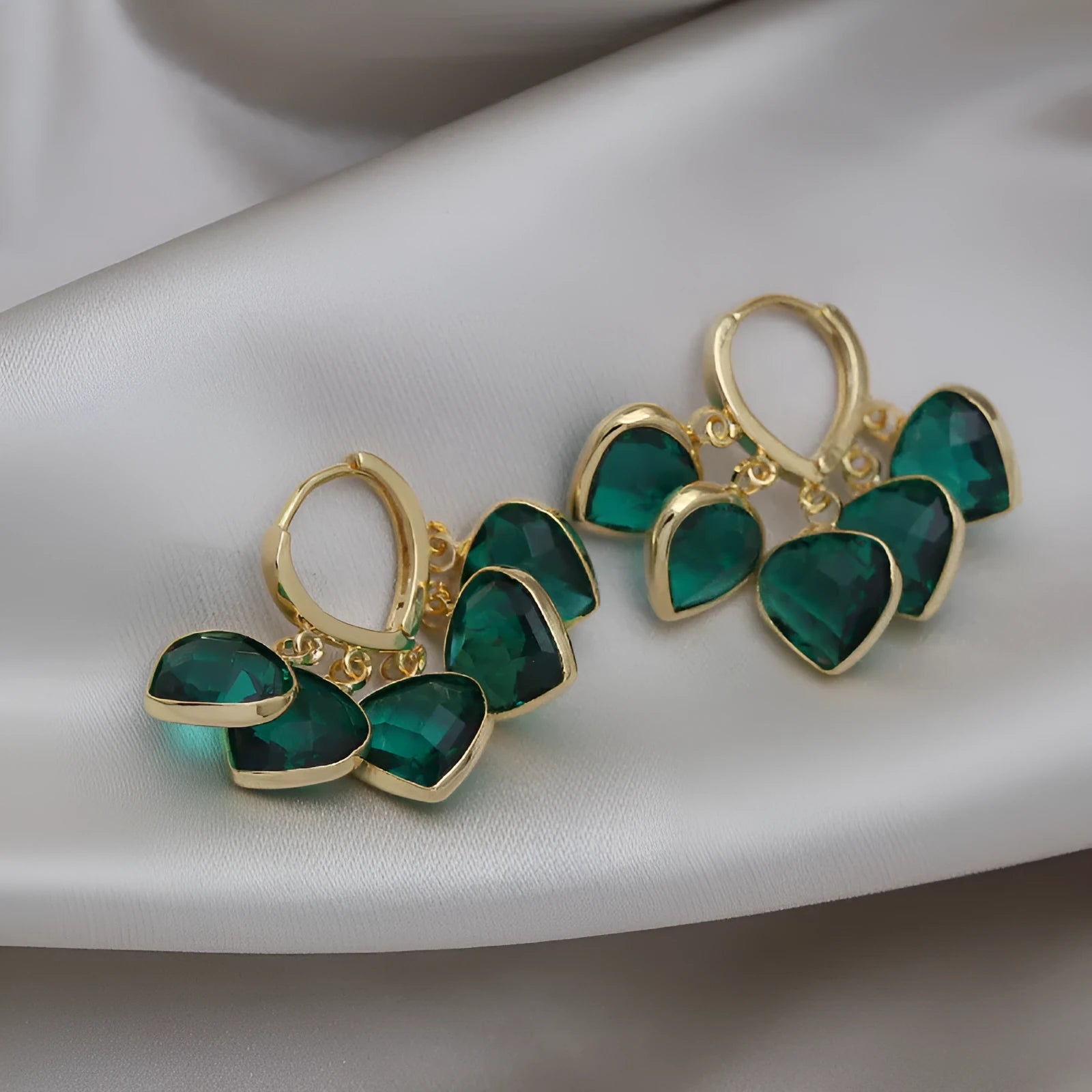 Pair of green heart-shaped glass pendant ear clip earrings with alloy and artificial gemstone details.