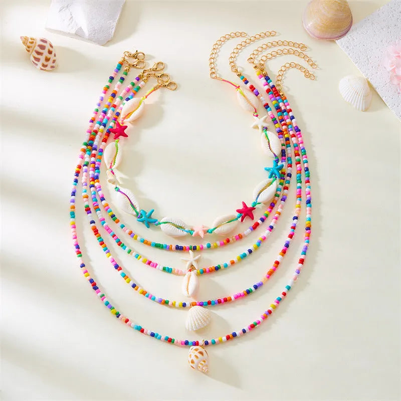 Five women's necklaces with starfish, shell and conch bead pendants on adjustable chains
