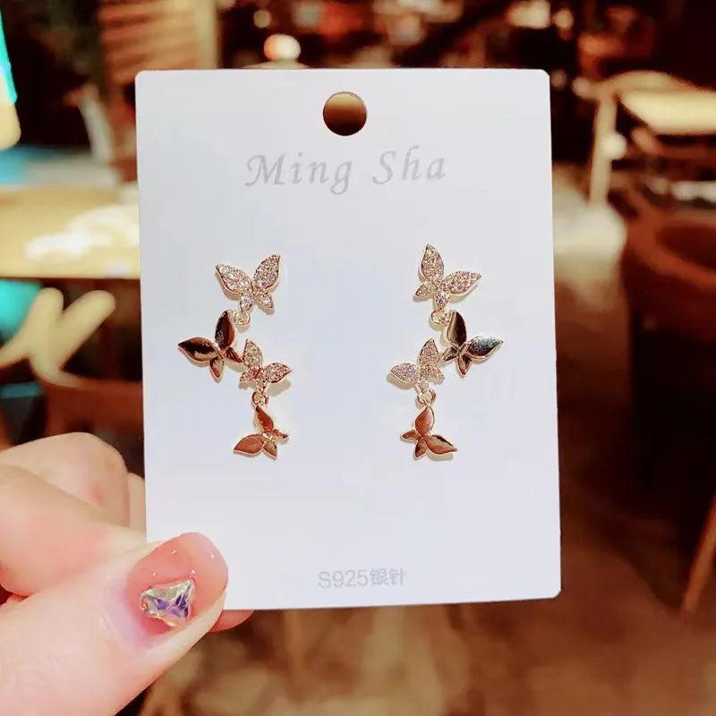 Women's copper butterfly drop earrings with four motifs in gold colour
