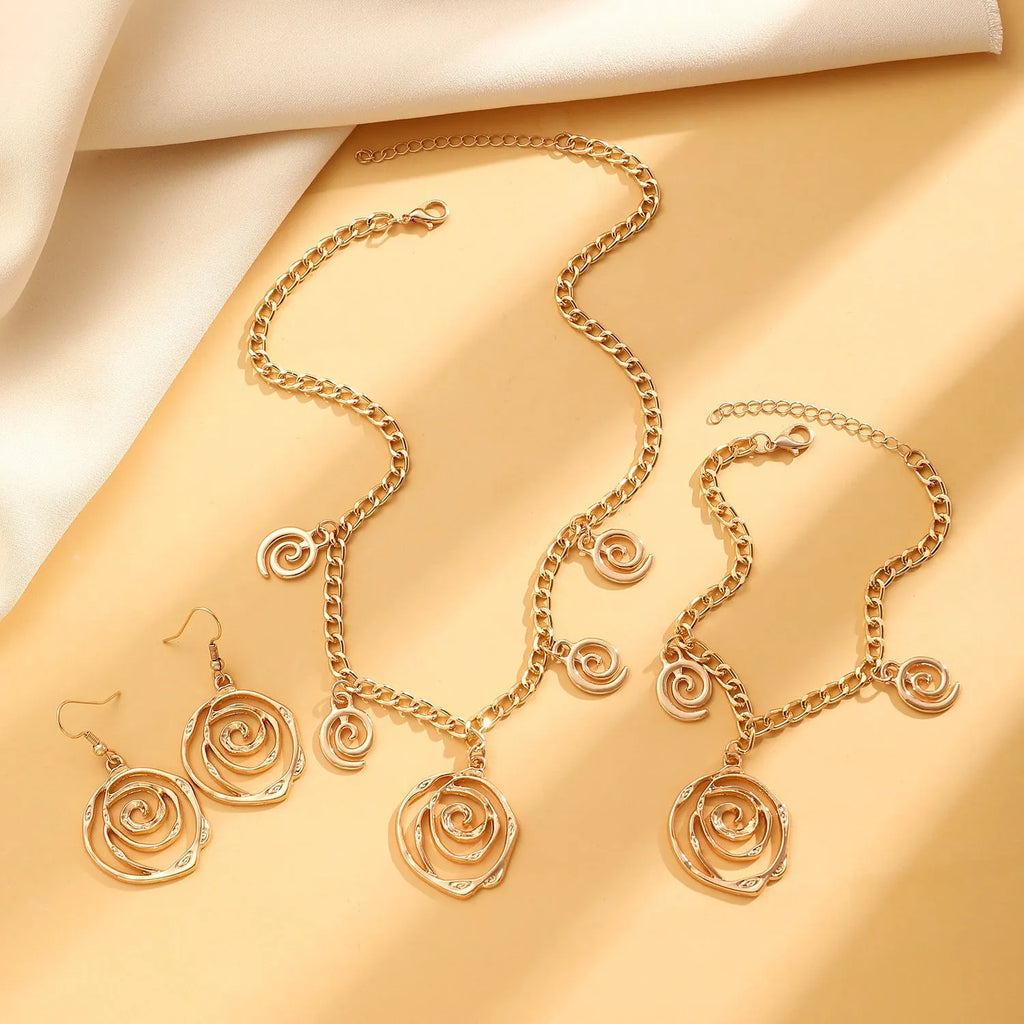 Spiral donut jewellery set showing necklace, bracelet and ear hooks in gold finish with geometric circle design