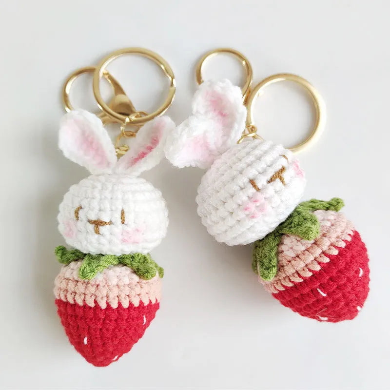 Hand-woven white rabbit and strawberry cartoon pendant on a key, made from braided doll wire.