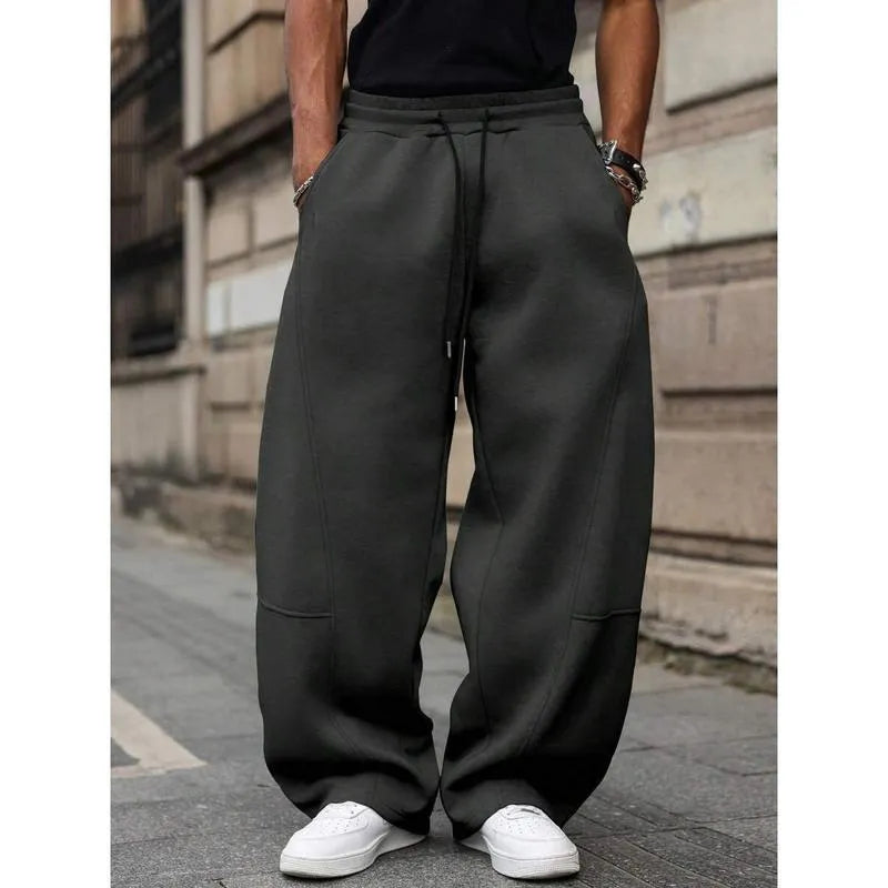 Man wearing dark grey high-waist straight-leg casual trousers made from elastic bamboo fibre fabric.