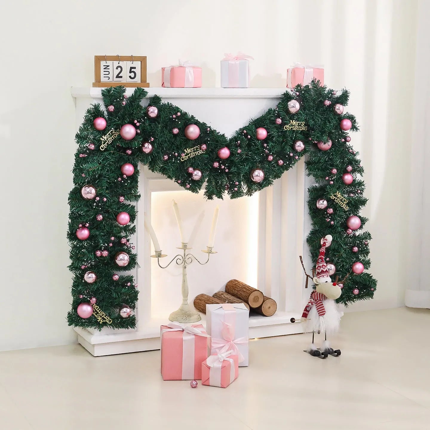 Pink artificial Christmas rattan garland with small berries and warm white LED lights draped on a mantelpiece.