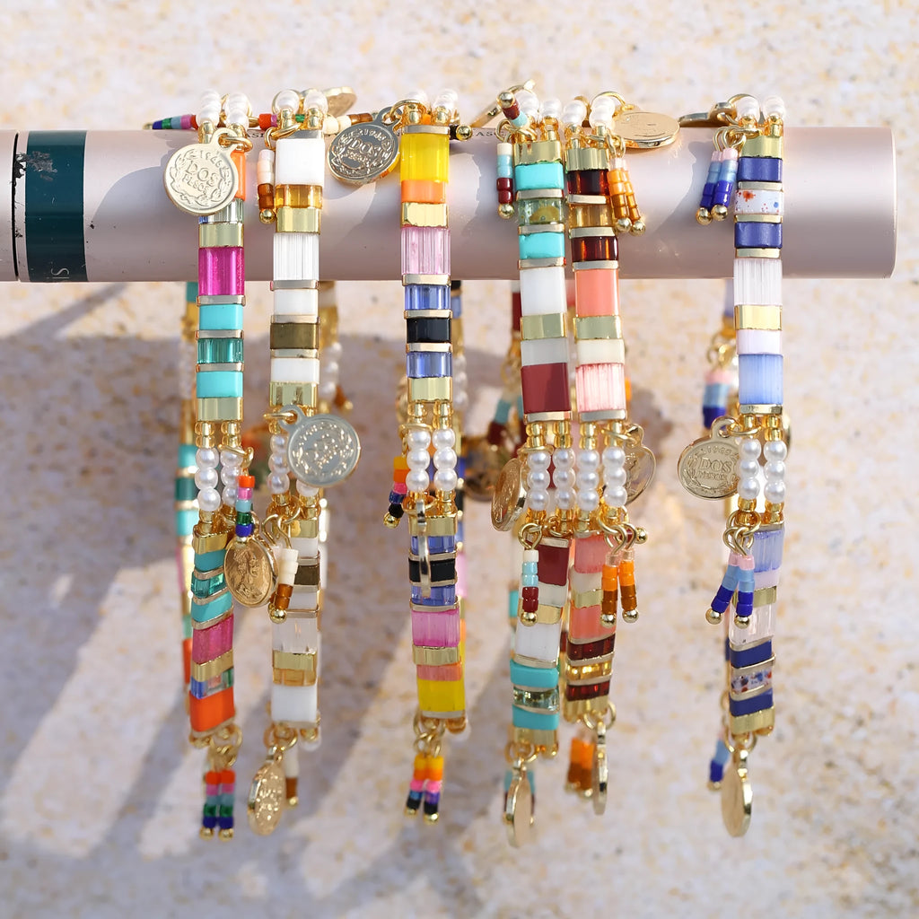 Handcrafted women's bracelet featuring imitation pearls and coloured glass beads on a wrist.