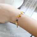 Handcrafted women's bracelet featuring imitation pearls and coloured glass beads on a wrist.
