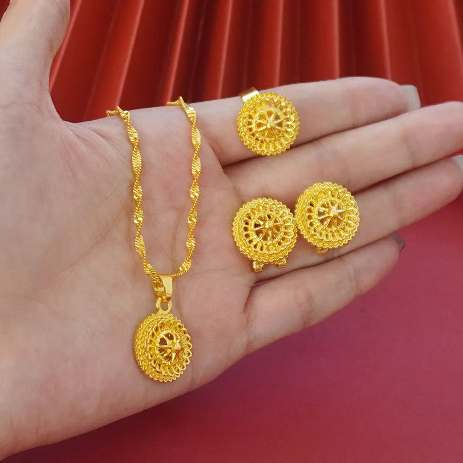 Gold-plated three-piece jewellery set with floral designs including necklace, earrings, and ring