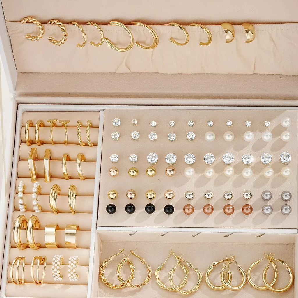 108 gold and yellow alloy stud earrings with geometric shapes and round pearl details on a plain surface.