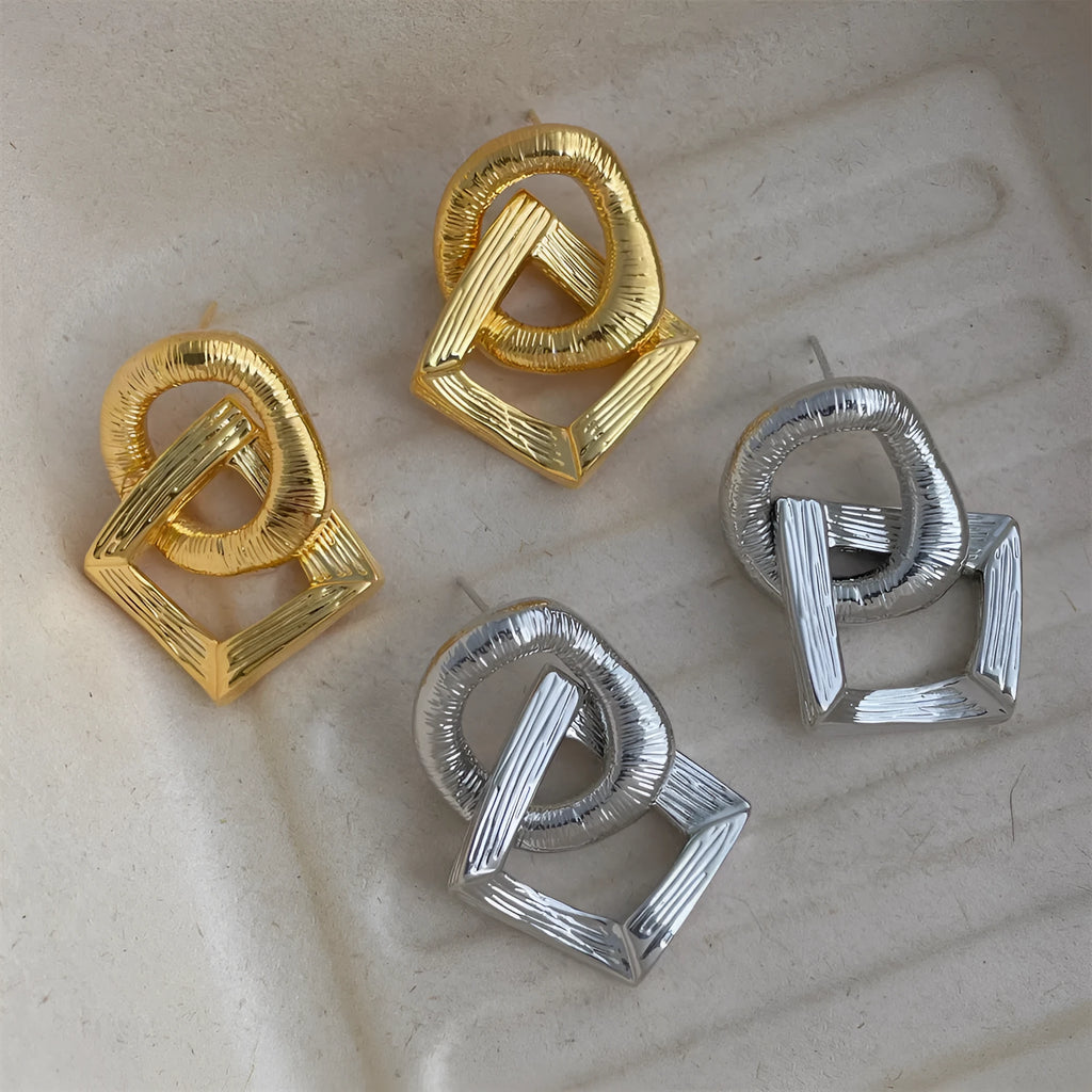 Geometric circle drop pendant earrings in gold or silver finish, showing 3.4cm length on a copper base.