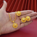 Gold-plated three-piece jewellery set with floral designs including necklace, earrings, and ring