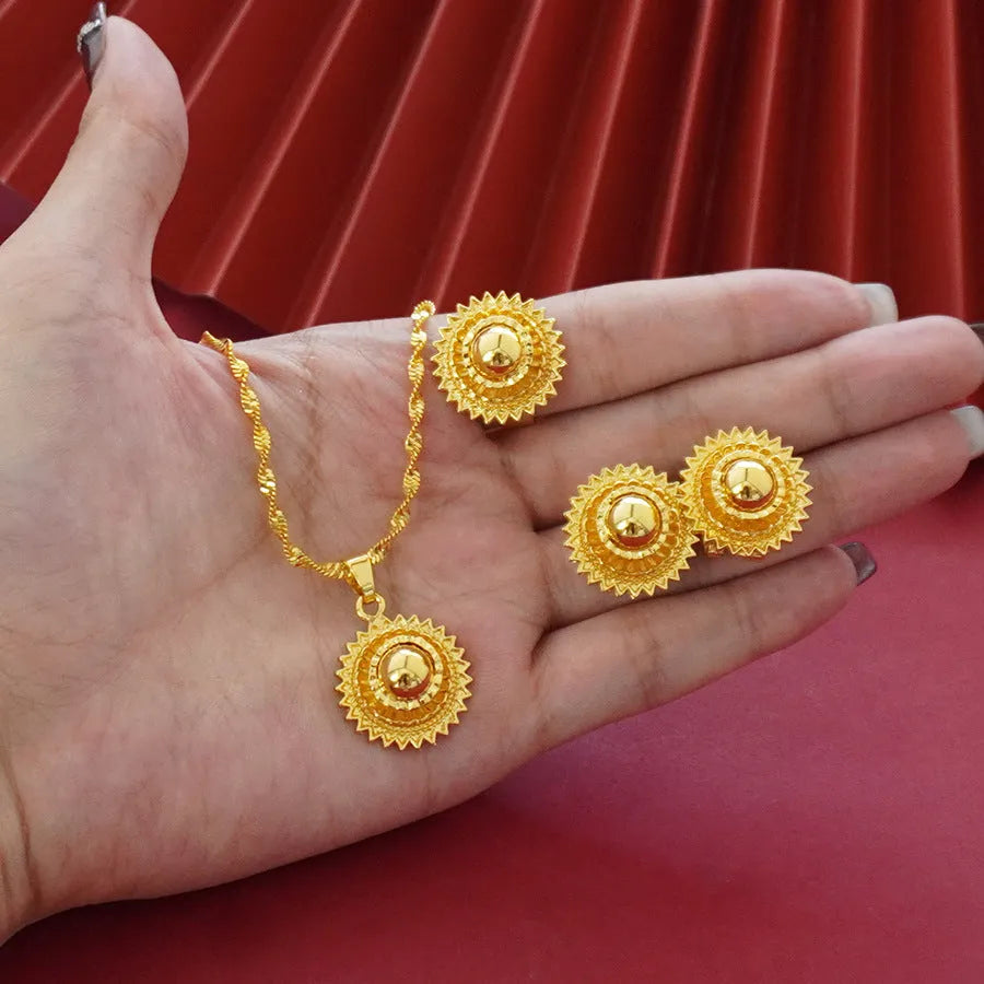Gold-plated three-piece jewellery set with floral designs including necklace, earrings, and ring