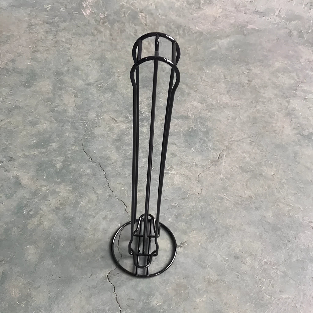 Black wrought iron coffee capsule storage rack holding 20 capsules on two shelves