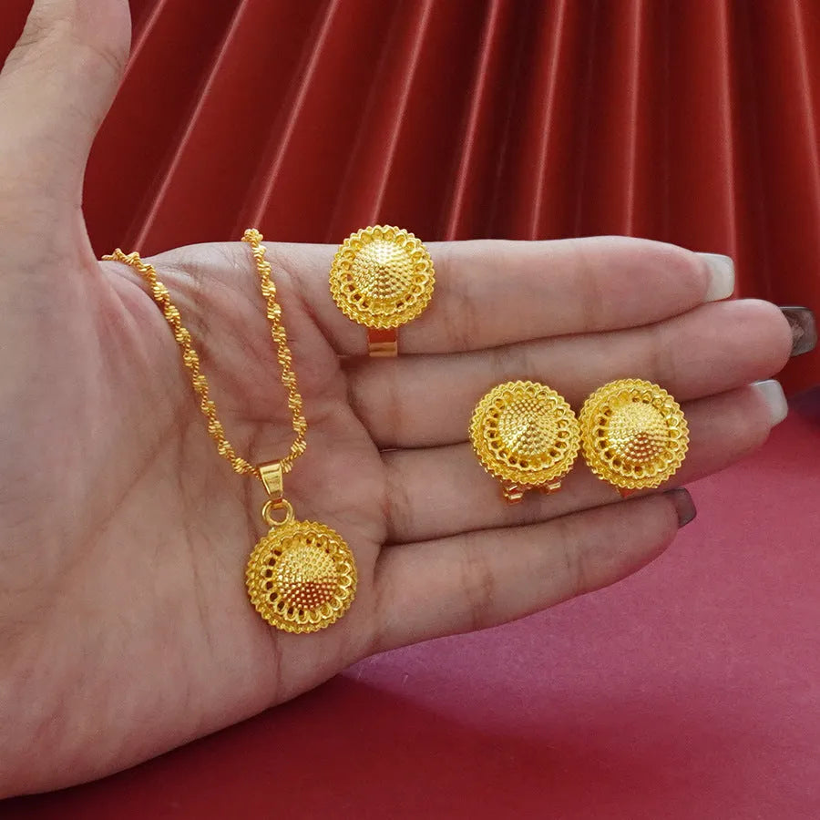 Gold-plated three-piece jewellery set with floral designs including necklace, earrings, and ring