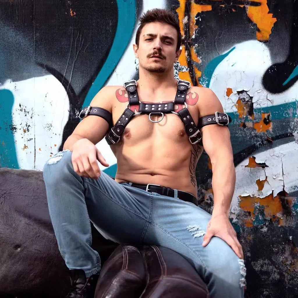 Black leather chest muscle bondage strap with metal buckle and rivet details
