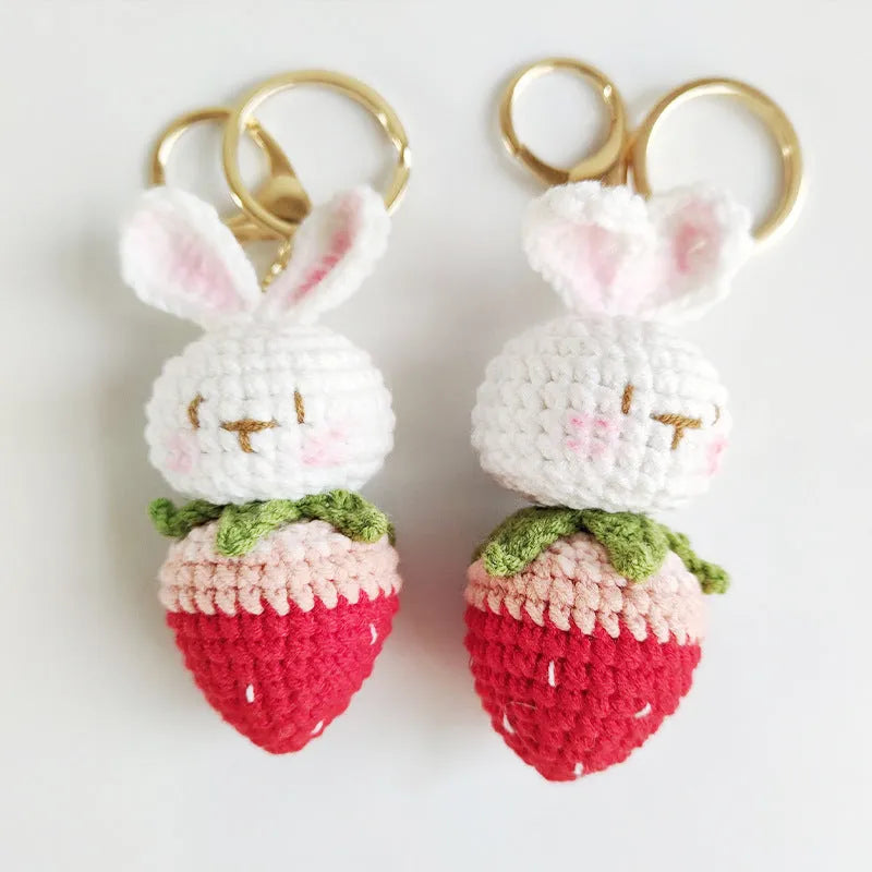 Hand-woven white rabbit and strawberry cartoon pendant on a key, made from braided doll wire.