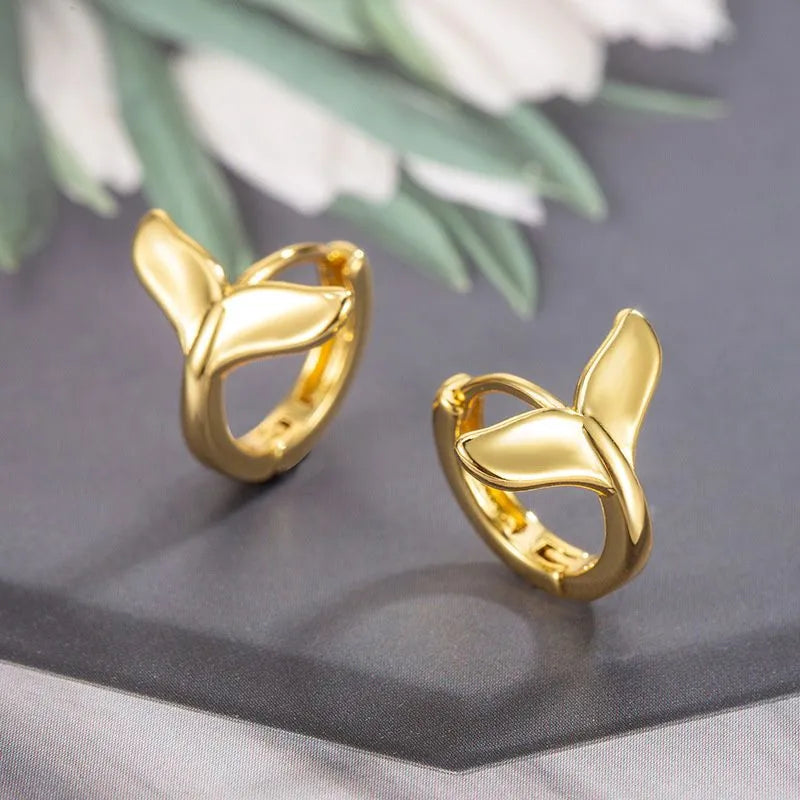 Women's fishtail design earrings in electroplated White Gold colour on a white background.