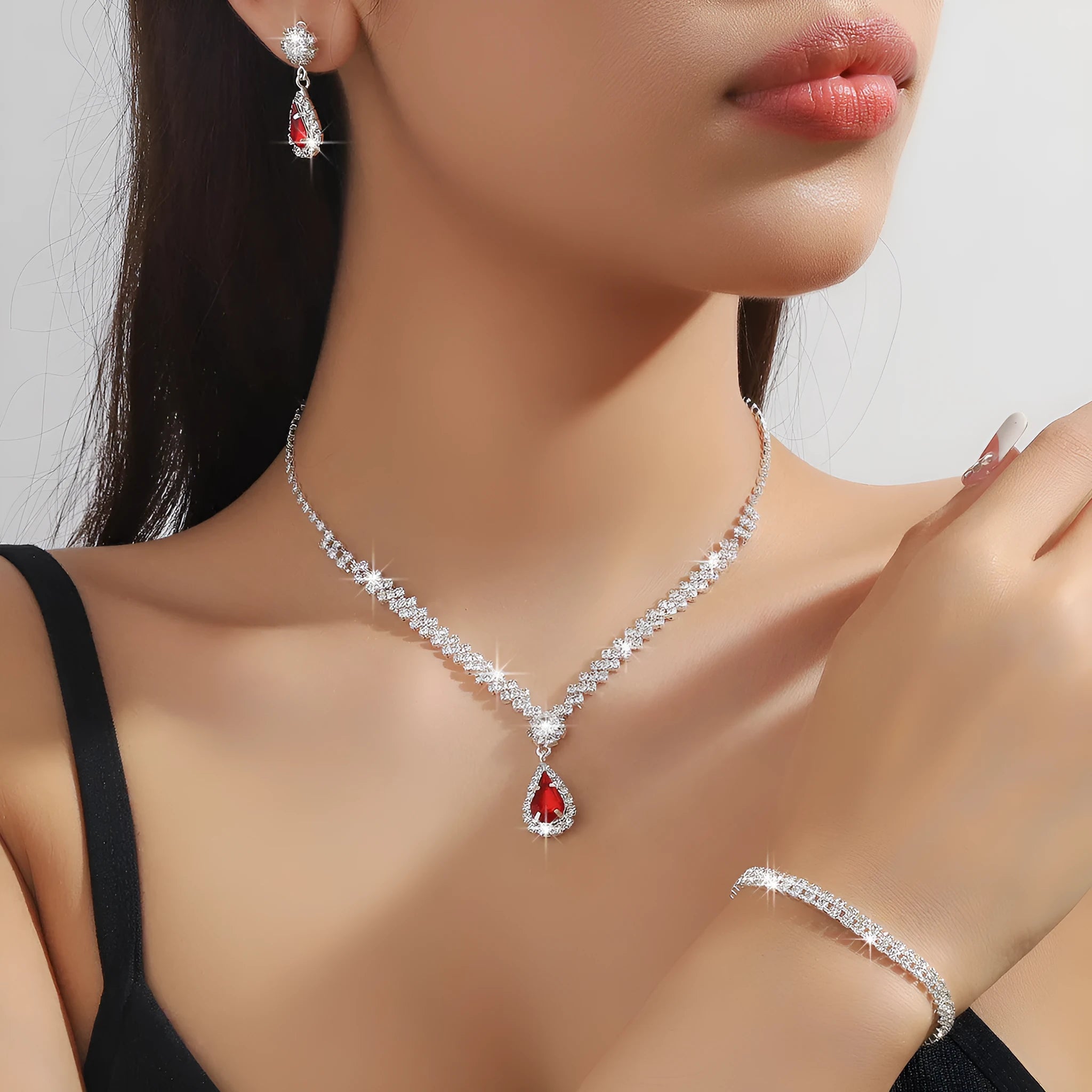 Women's rhinestone water drop necklace and earrings set on a claw chain in blue colour.