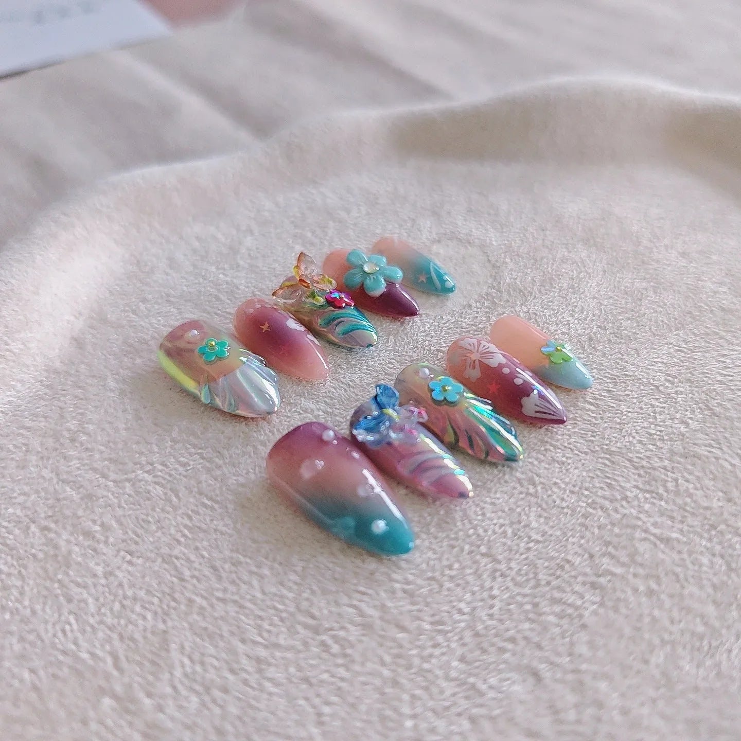 Handmade acrylic press-on nails with colourful 3D embossed flower and butterfly sculptures in almond shape.