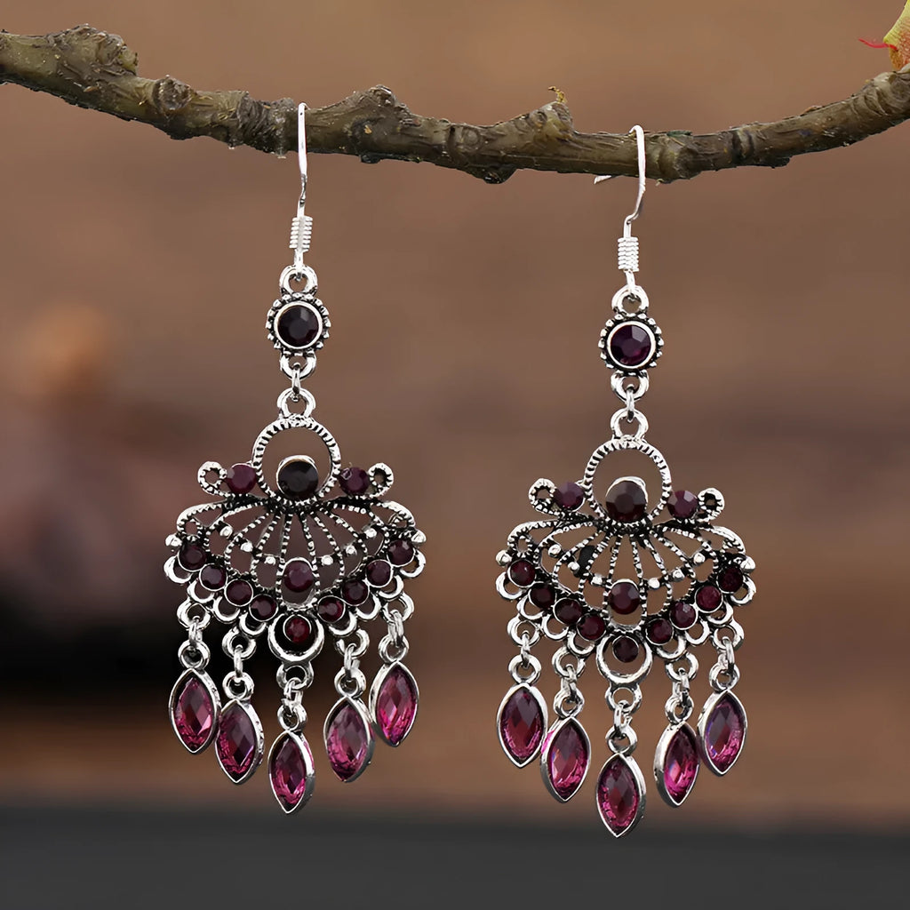 Close-up of long purple drop earrings with crystal fringe detail on an alloy setting.