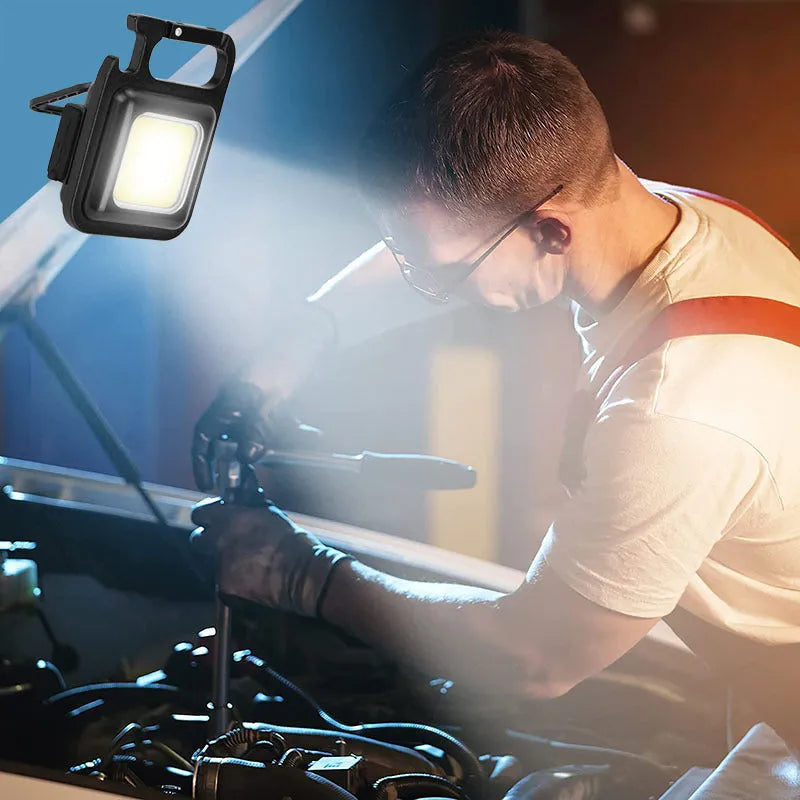 Black aluminium alloy USB rechargeable keychain light with LED, magnet, and folding handle