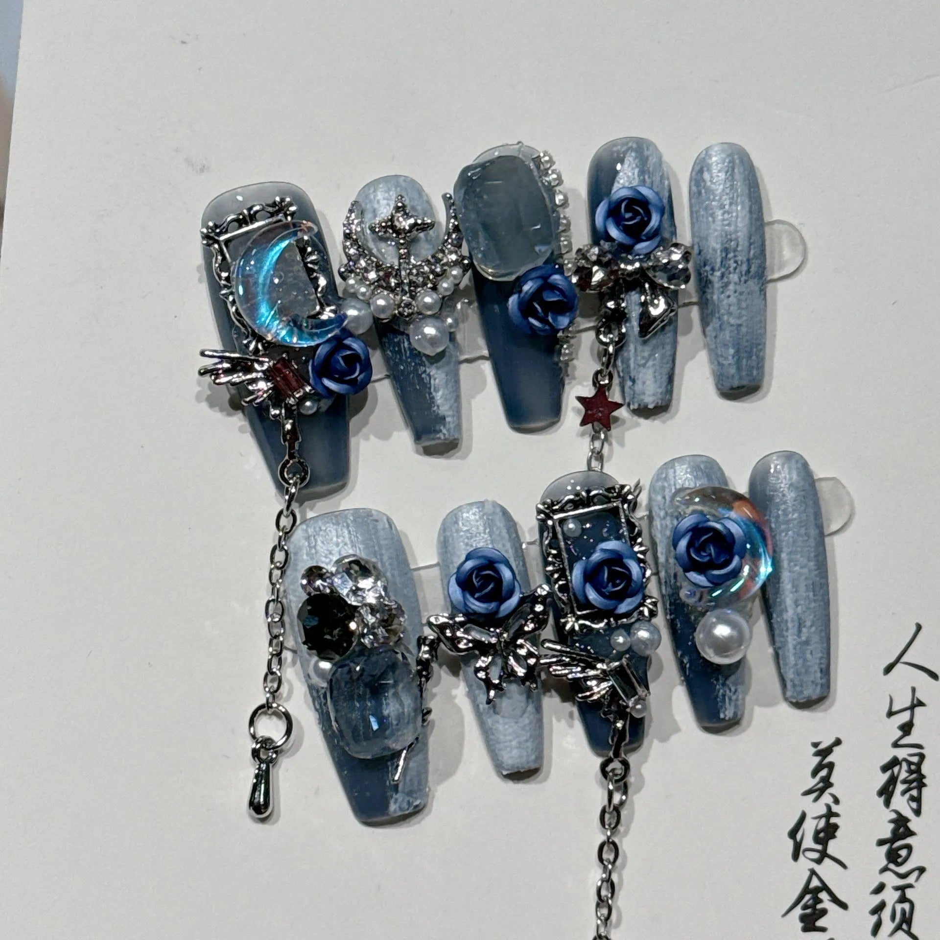 Heavy industry blue manicure nails with rose and tulip floral patterns in plastic armour suit packaging
