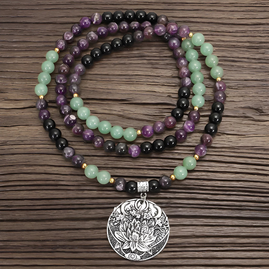 Long yoga necklace with lotus pendant and stone beads alongside matching bracelet